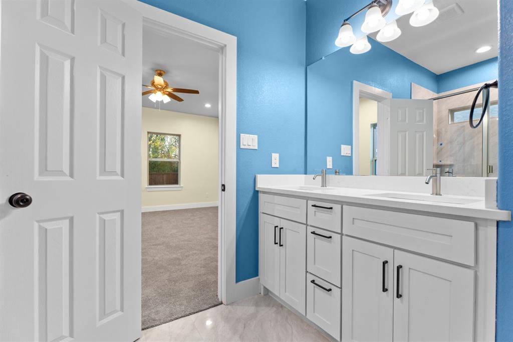 520 East 5th Street Bonham, TX 75418 - Photo 11 of 16 a bathroom with a double vanity sink and a mirror