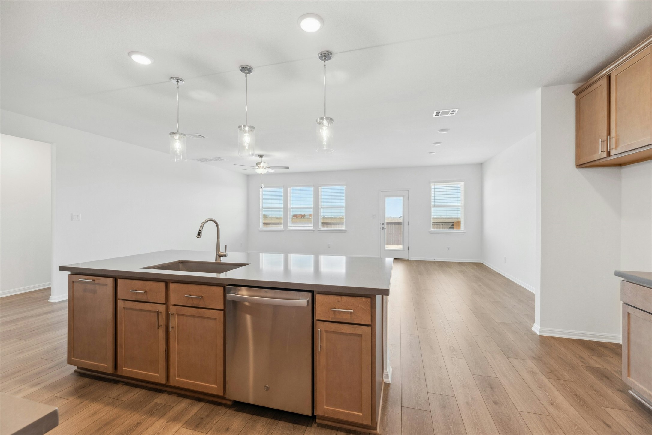 2001 Wynn Road Hutto, TX 78634 - Photo 10 of 39 A contemporary kitchen island features pendant lighting and durable hardwood-style flooring throughout the open living area.