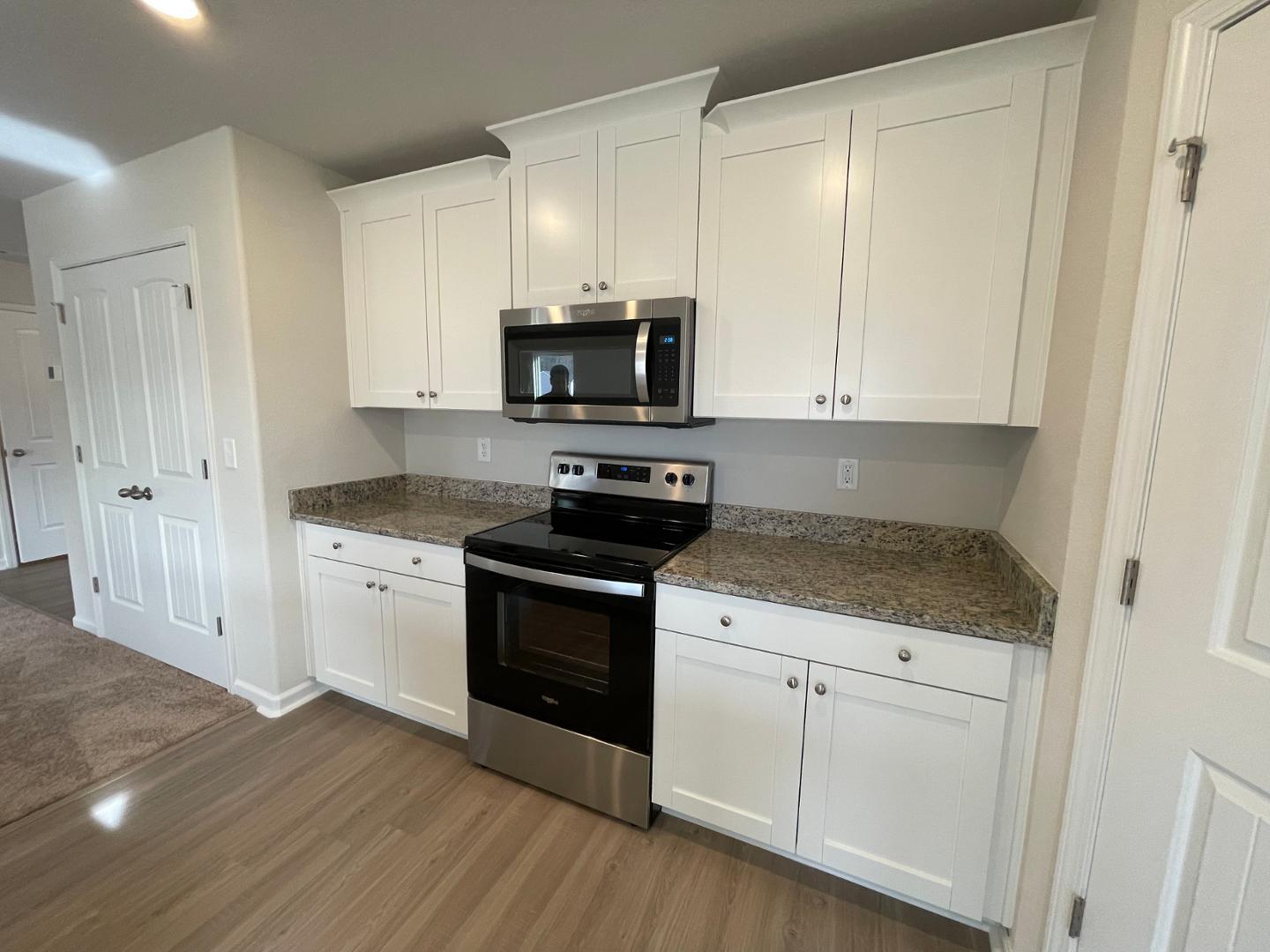 111 Hybrid Street Oxford, NC 27565 - Photo 7 of 25 a kitchen with granite countertop white cabinets and stainless steel appliances