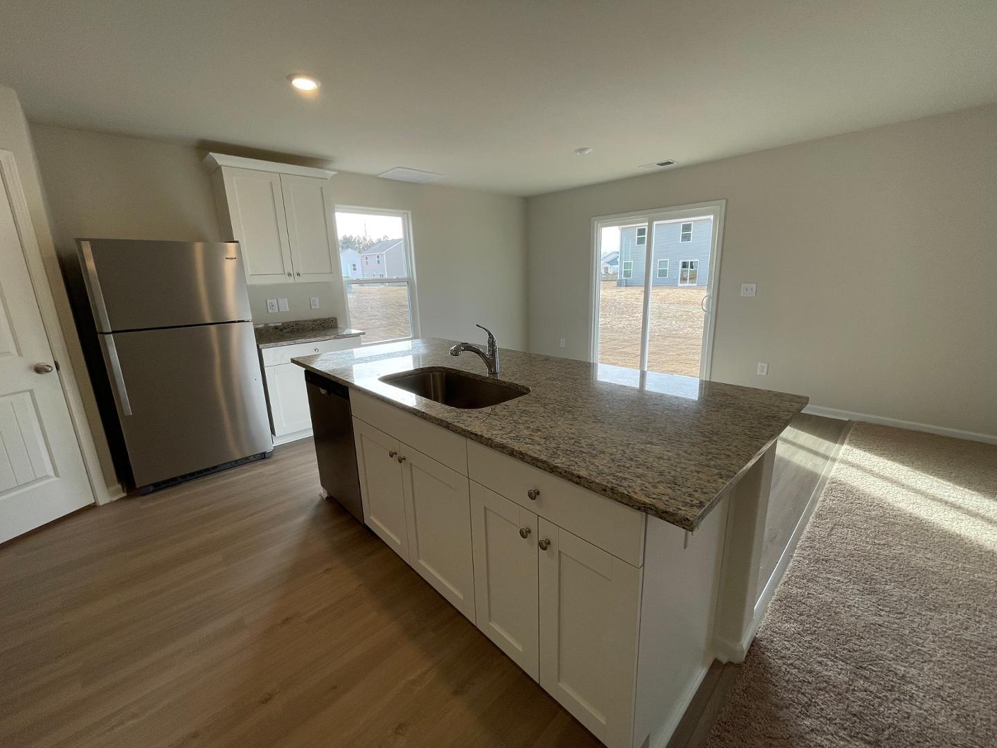 111 Hybrid Street Oxford, NC 27565 - Photo 8 of 25 a kitchen with granite countertop a refrigerator a sink a stove and wooden floor