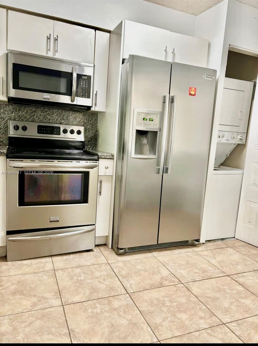 9081 Southwest 138th Place, Unit 9081 Miami, FL 33186 - Photo 8 of 20 a metallic refrigerator freezer and a stove sitting inside of a kitchen