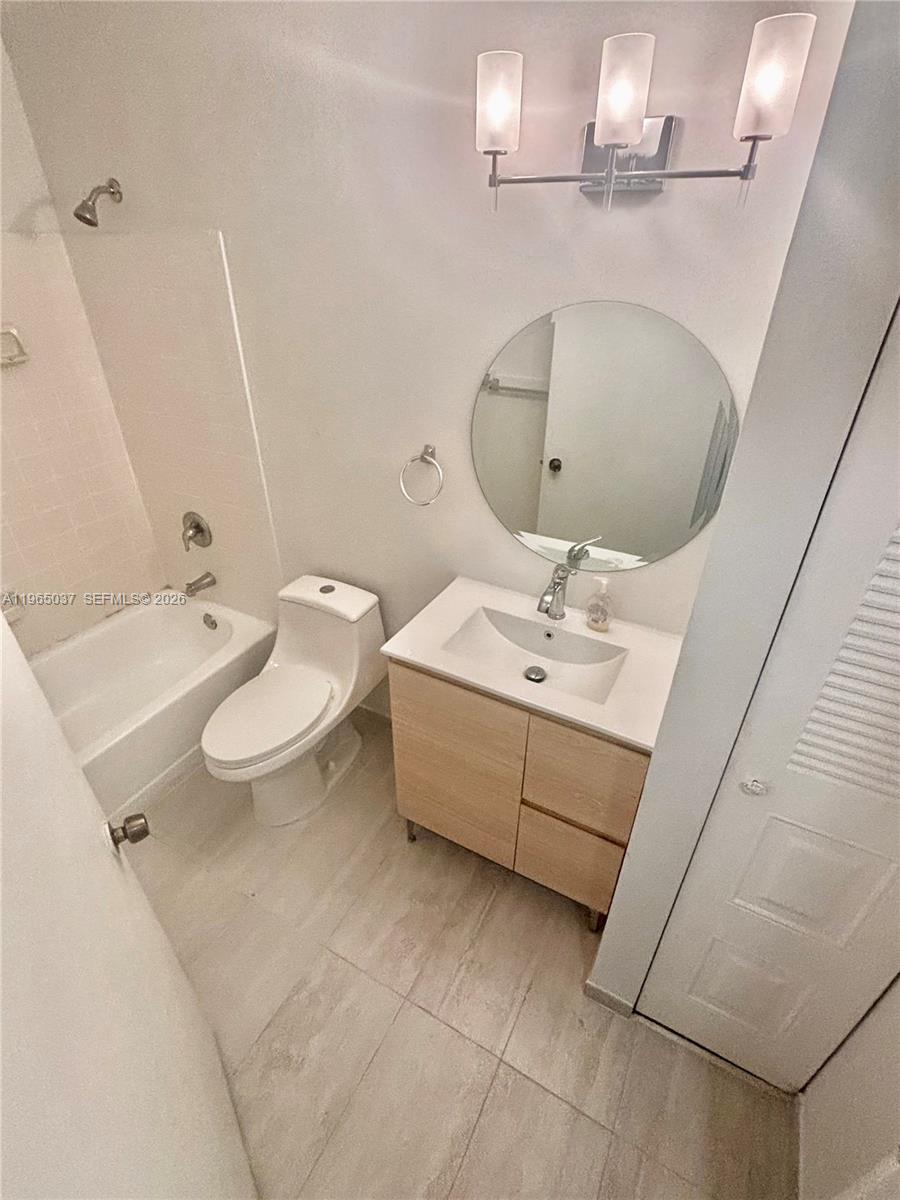 9081 Southwest 138th Place, Unit 9081 Miami, FL 33186 - Photo 9 of 20 a bathroom with a sink a toilet and mirror