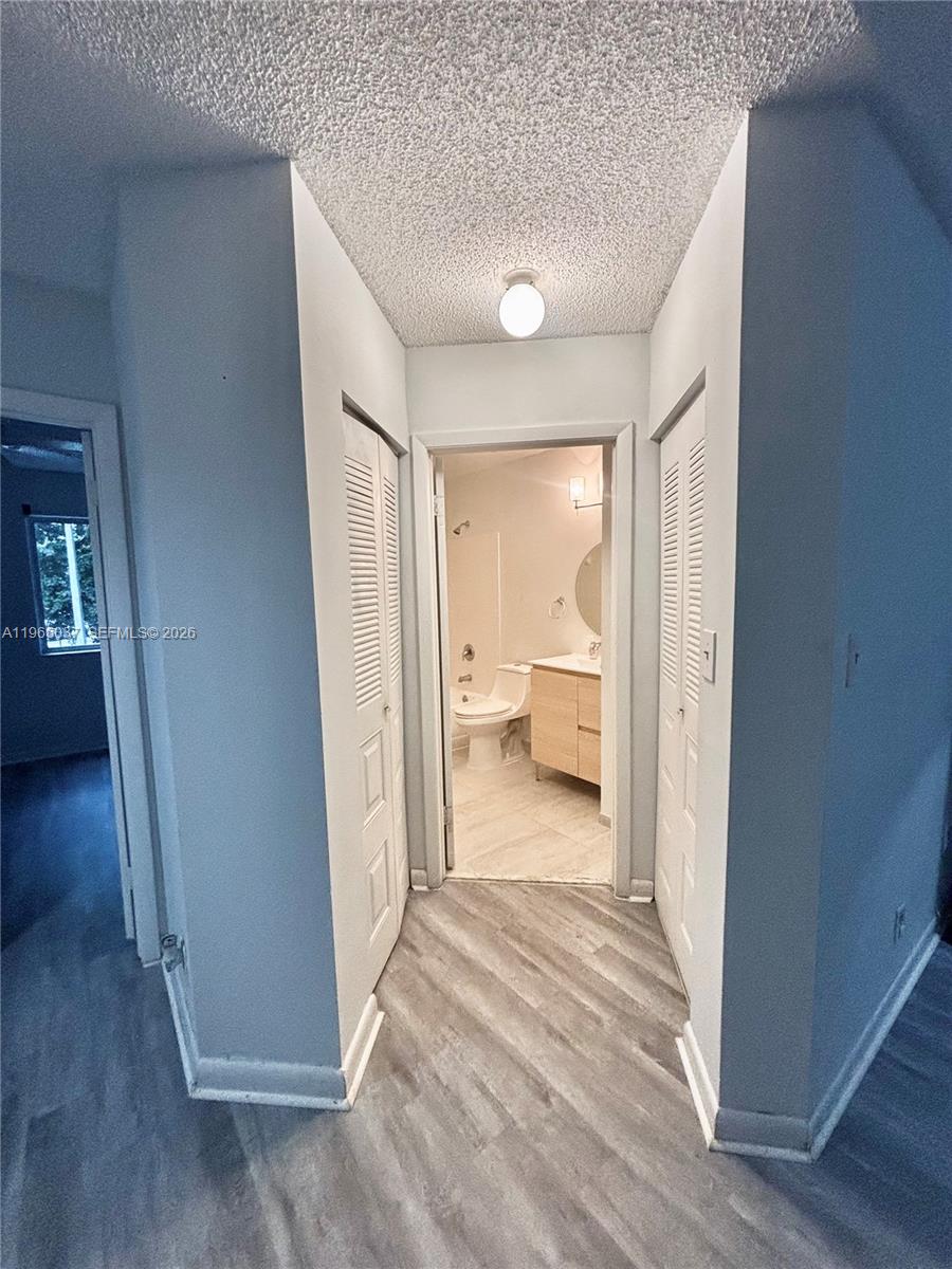 9081 Southwest 138th Place, Unit 9081 Miami, FL 33186 - Photo 10 of 20 a view of a room with wooden floor cabinet and bathroom