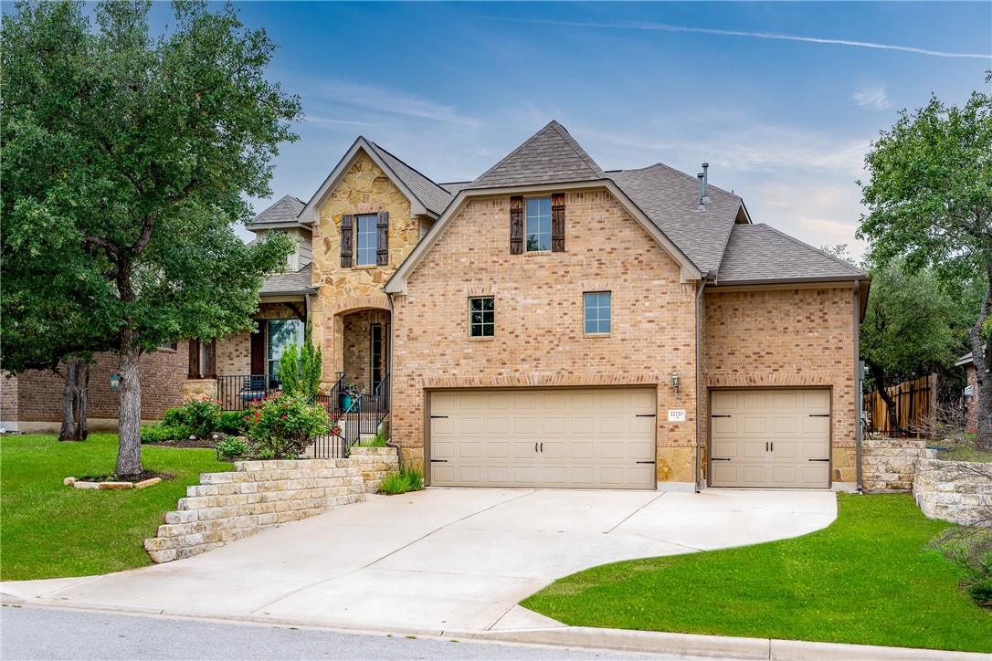 22220 Red Yucca Road Spicewood, TX 78669 - Photo 1 of 1 Beautiful 2 story brick home with lush green grass and 3 car garage.