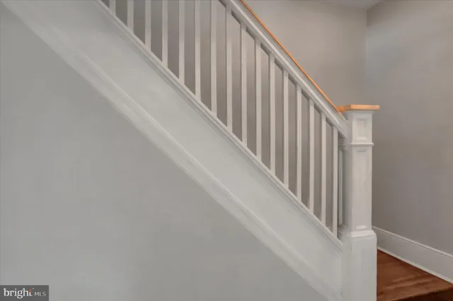 a view of staircase with railing and white walls