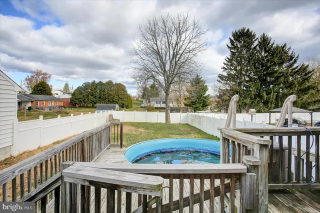 a view of a balcony with two chairs and wooden fence
