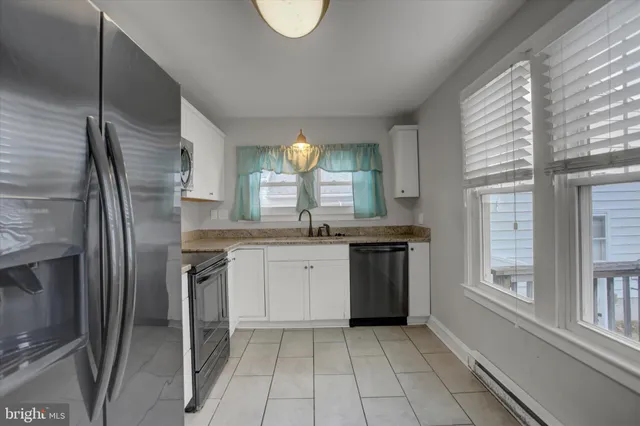 a kitchen with stainless steel appliances granite countertop a refrigerator a sink and a stove