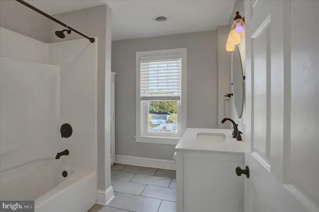 a bathroom with a tub sink and shower