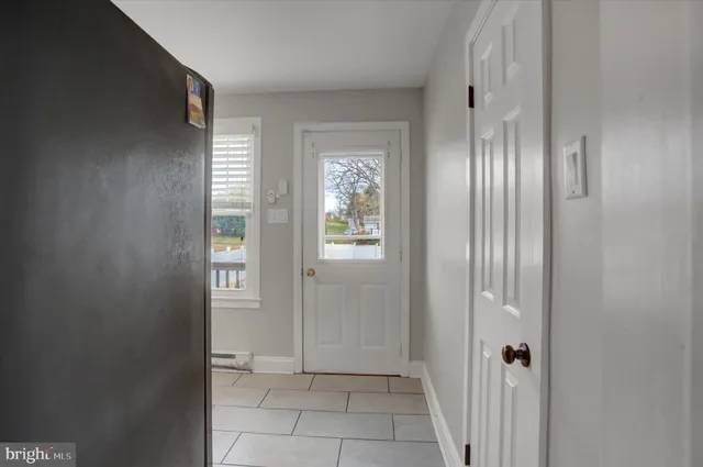 a view of a hallway with wooden floor and a bathroom
