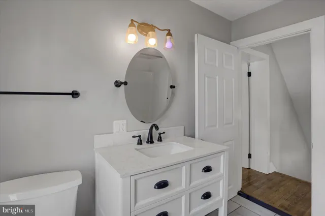 a bathroom with a sink vanity mirror and toilet