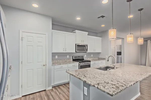 a kitchen with stainless steel appliances granite countertop a sink stove and cabinets