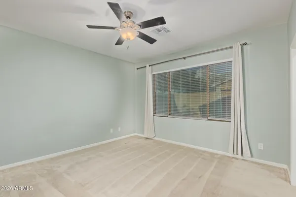 an empty room with a window and a ceiling fan