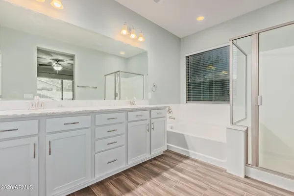 a spacious bathroom with double vanity a mirror a vanity and a shower