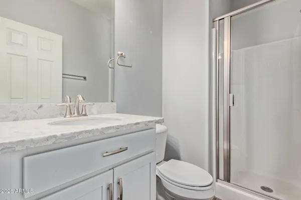a bathroom with a granite countertop sink toilet and a mirror