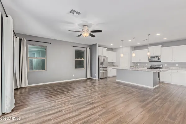 a view of kitchen with granite countertop cabinets and refrigerator