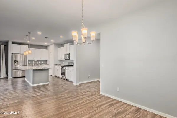 a view of kitchen with granite countertop cabinets and refrigerator