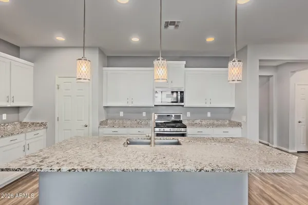 a kitchen with granite countertop a sink a counter top space appliances and cabinets