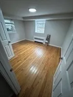 a view of empty room with wooden floor and windows