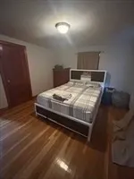 a bed sitting in a bedroom next to a lamp