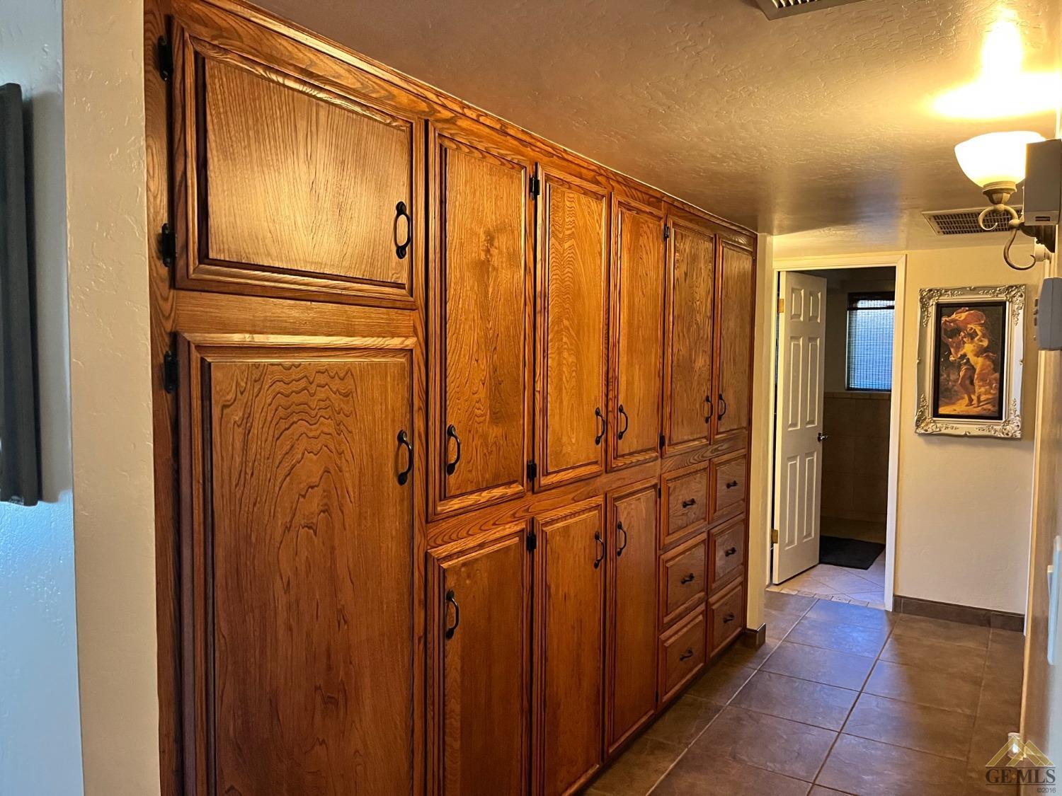 Undisclosed Address Bakersfield, CA 93309 - Photo 16 of 28 a view of a hallway with wooden cabinets