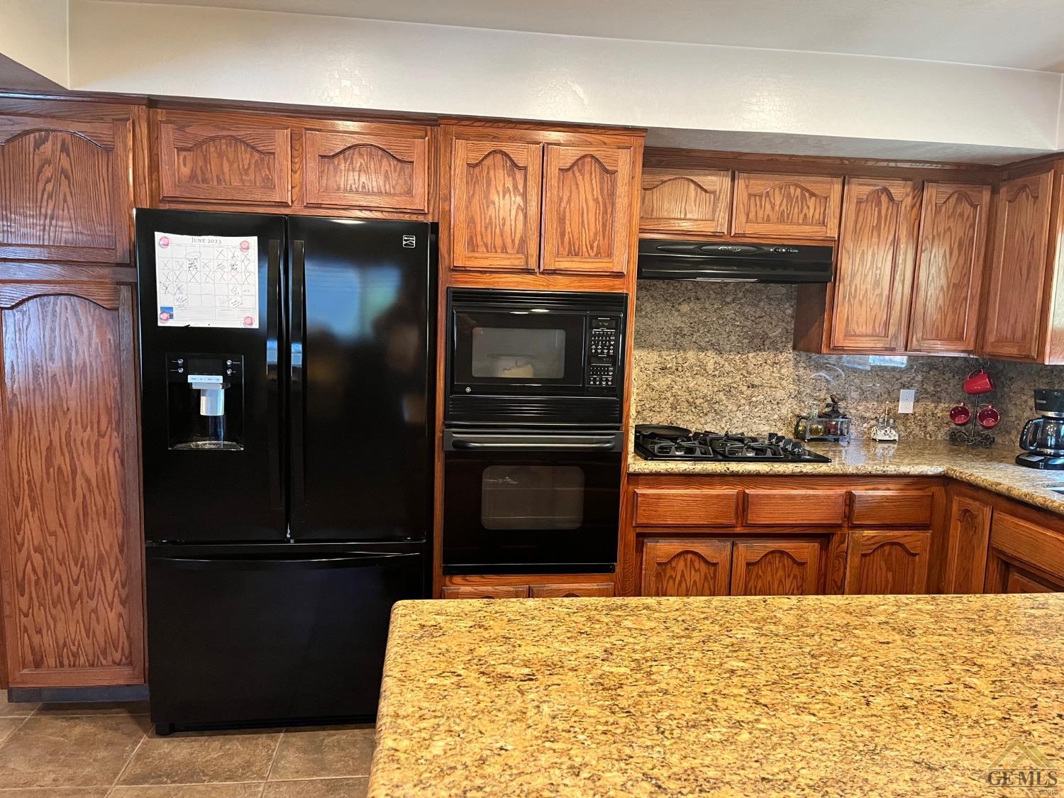 Undisclosed Address Bakersfield, CA 93309 - Photo 6 of 28 a kitchen with granite countertop a refrigerator and a sink