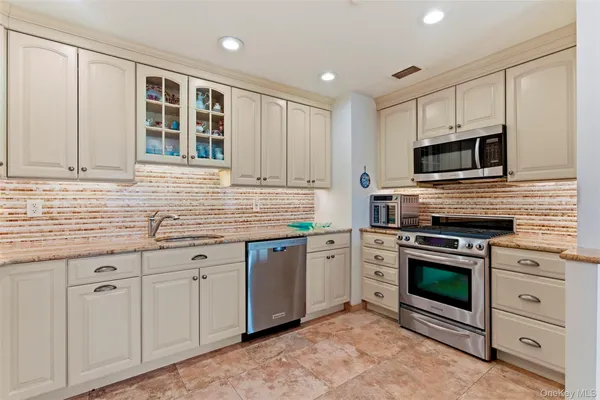 a kitchen with granite countertop cabinets stainless steel appliances and a sink