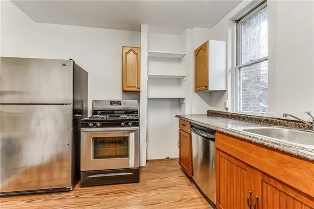 a kitchen with stainless steel appliances granite countertop a stove a sink and a refrigerator