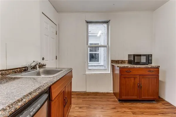 a kitchen with granite countertop kitchen island stainless steel appliances a sink stove and window