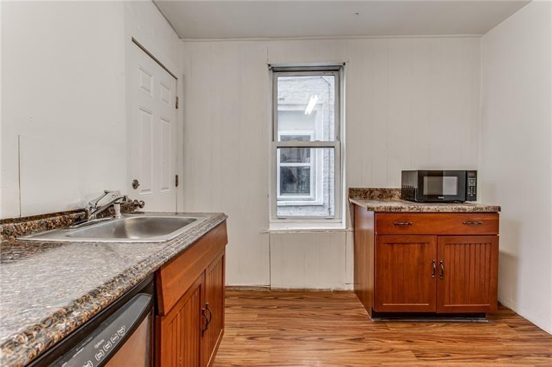 354 Ophelia Street Pittsburgh, PA 15213 - Photo 12 of 28 a kitchen with granite countertop kitchen island stainless steel appliances a sink stove and window