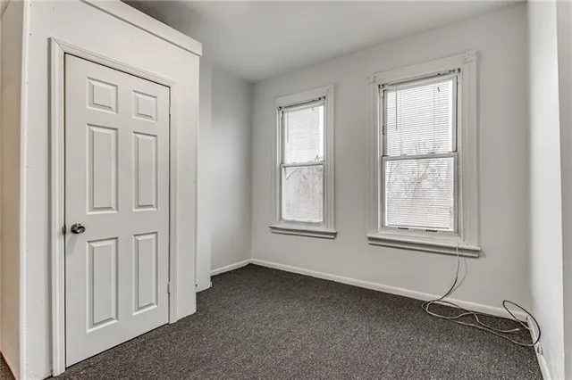 an empty room with windows and closet