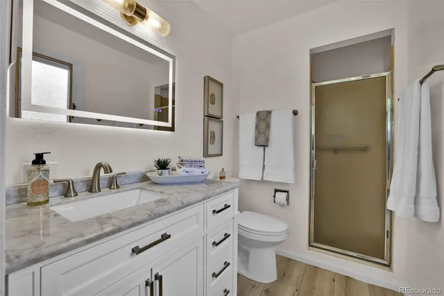 a bathroom with a granite countertop toilet sink and shower