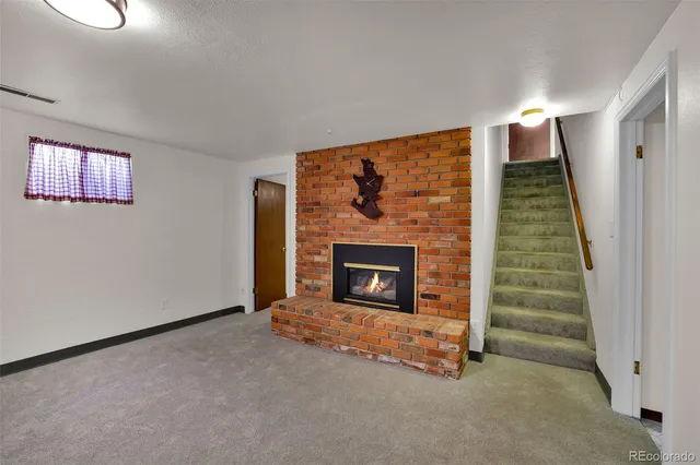 a view of an empty room with a fireplace and window