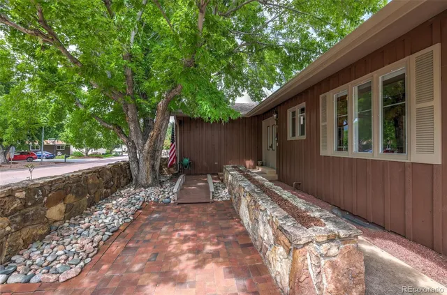 a backyard of a house with table and chairs a barbeque with wooden fence