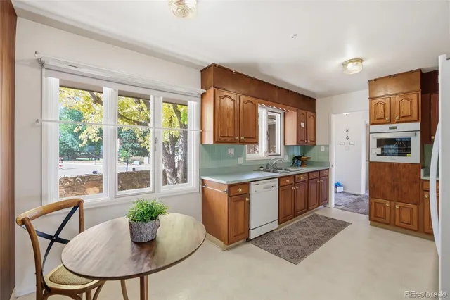 a kitchen with stainless steel appliances granite countertop a stove a sink a microwave a dining table and chairs