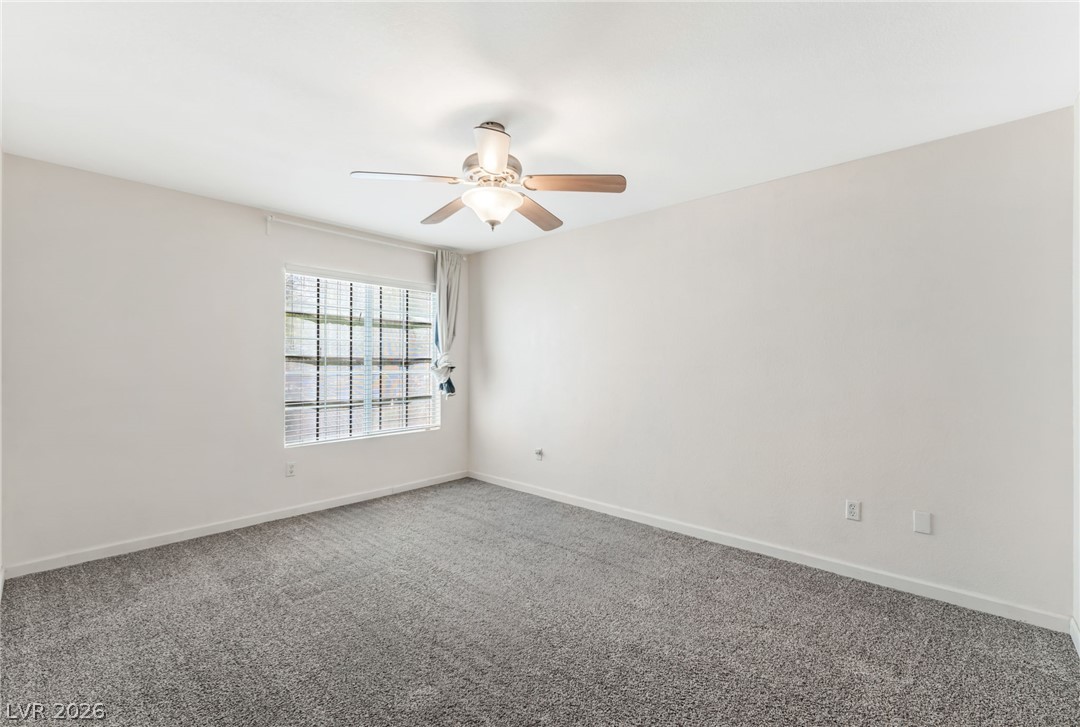 1901 Rio Canyon Court, Unit 102 Las Vegas, NV 89128 - Photo 11 of 23 A comfortable bedroom with a practical ceiling fan, ready for your personal touch.