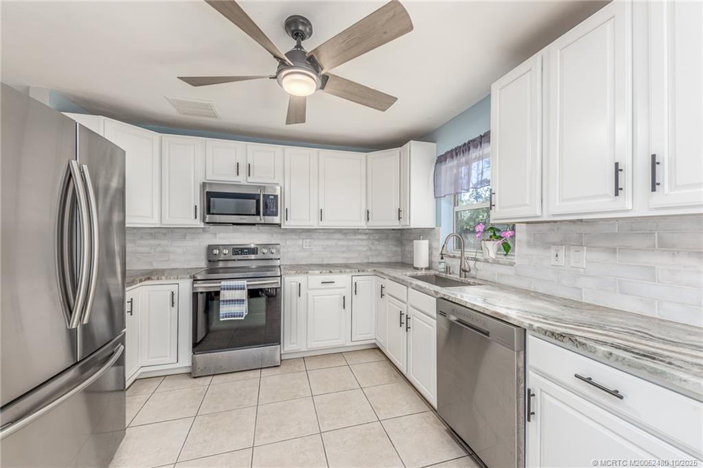 3156 Southeast Mimosa Street Stuart, FL 34997 - Photo 17 of 38 a kitchen with cabinets stainless steel appliances and a counter space