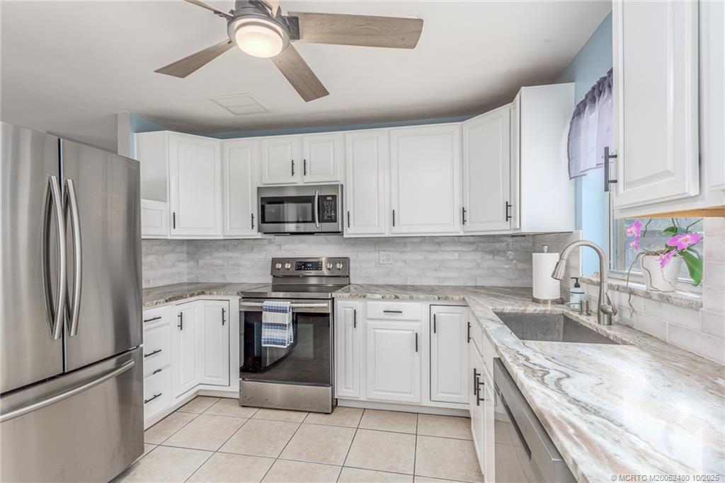 3156 Southeast Mimosa Street Stuart, FL 34997 - Photo 18 of 38 a kitchen with a stove sink and refrigerator