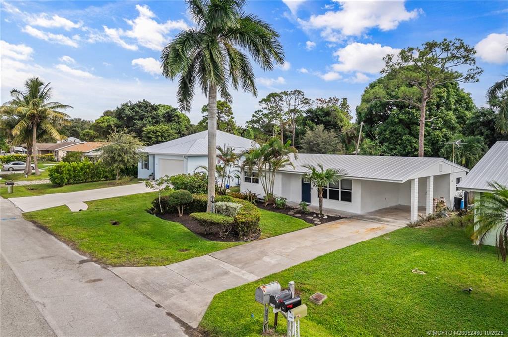 3156 Southeast Mimosa Street Stuart, FL 34997 - Photo 2 of 38 a front view of a house with garden