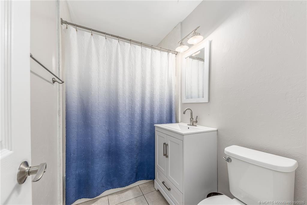 3156 Southeast Mimosa Street Stuart, FL 34997 - Photo 22 of 38 a bathroom with a sink a toilet and shower