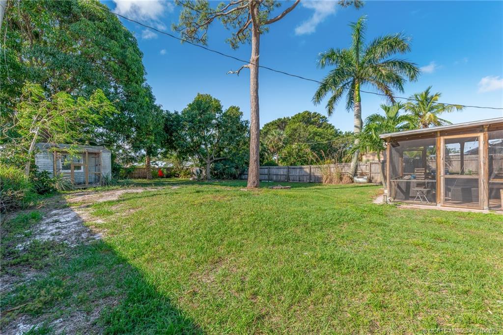 3156 Southeast Mimosa Street Stuart, FL 34997 - Photo 27 of 38 a view of a house with a yard and palm trees