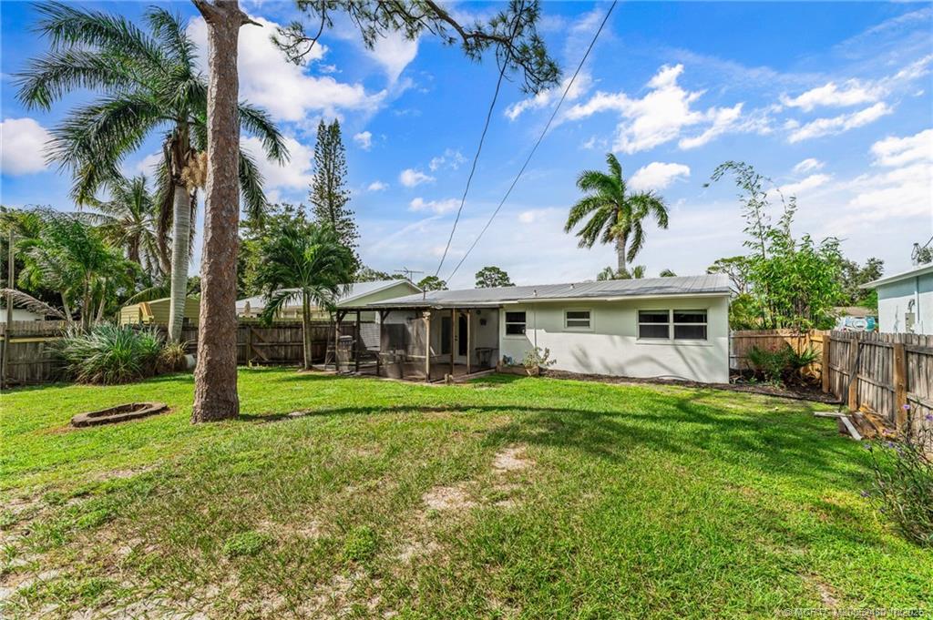 3156 Southeast Mimosa Street Stuart, FL 34997 - Photo 37 of 38 a view of a house with a big yard and potted plants and large trees