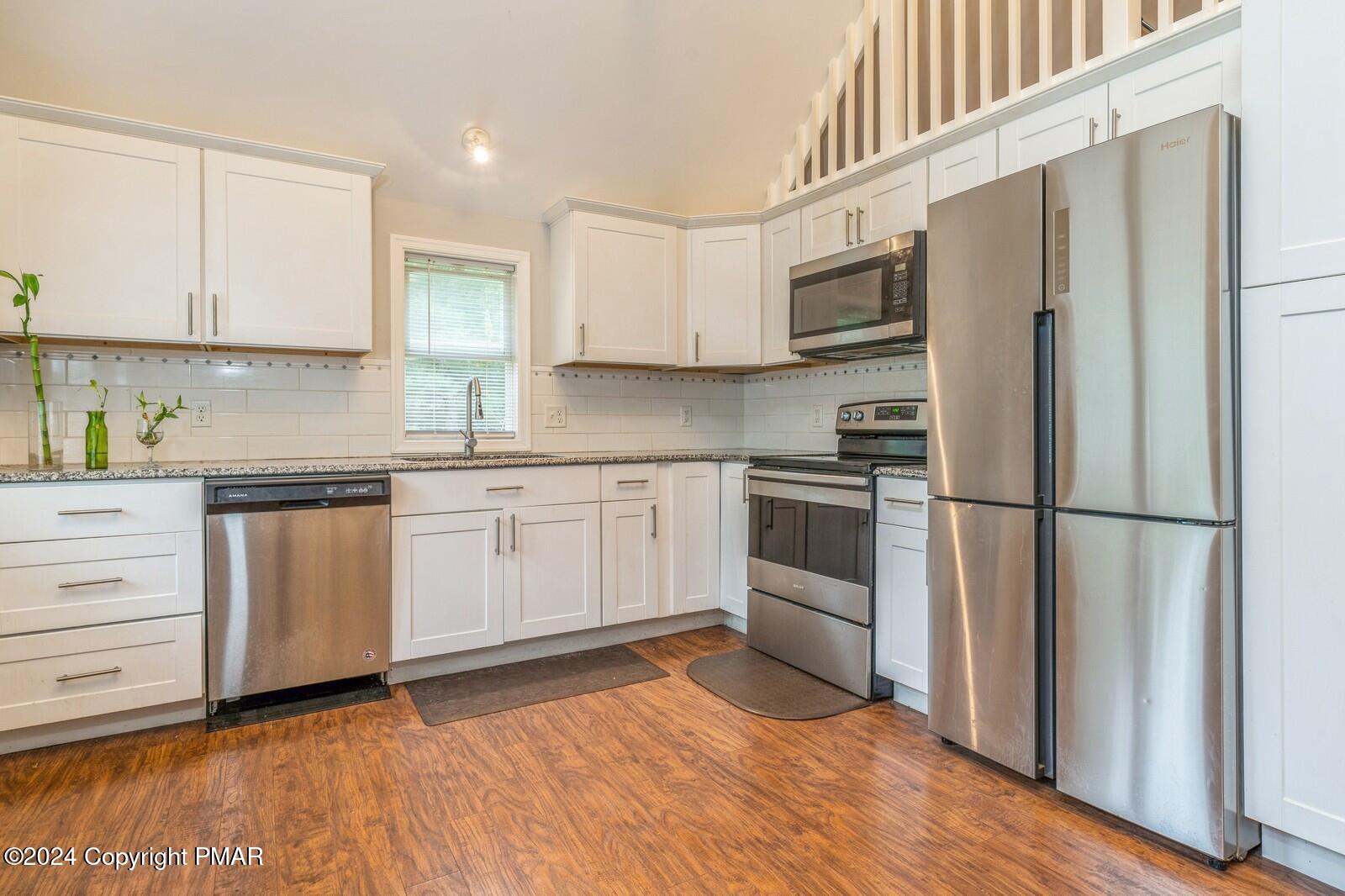 104 Swan Drive Dingmans Ferry, PA 18328 - Photo 11 of 36 a kitchen with white cabinets and white appliances