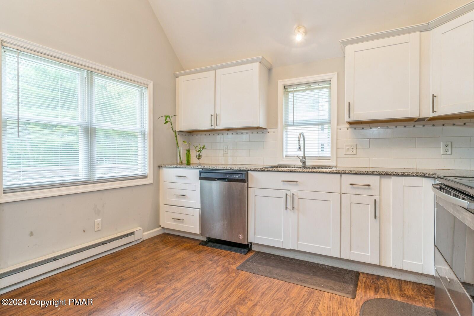 104 Swan Drive Dingmans Ferry, PA 18328 - Photo 12 of 36 a kitchen with granite countertop white cabinets and white appliances