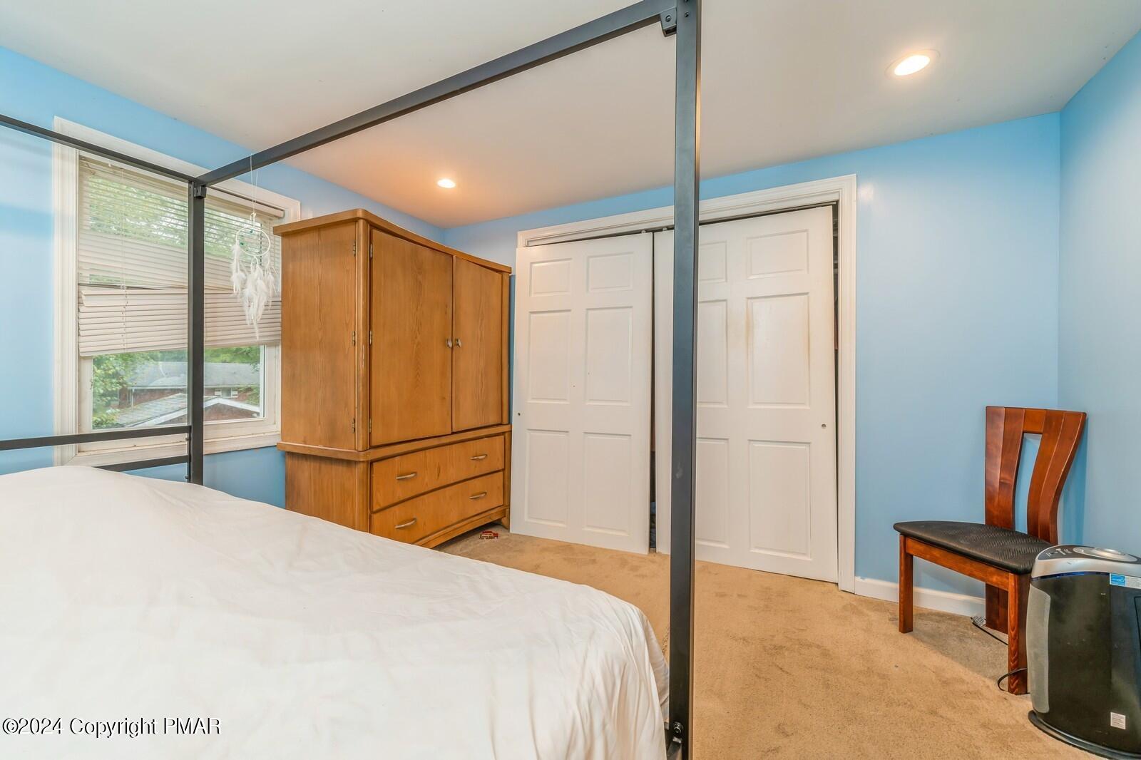 104 Swan Drive Dingmans Ferry, PA 18328 - Photo 20 of 36 a bedroom with a bed and a chair in it