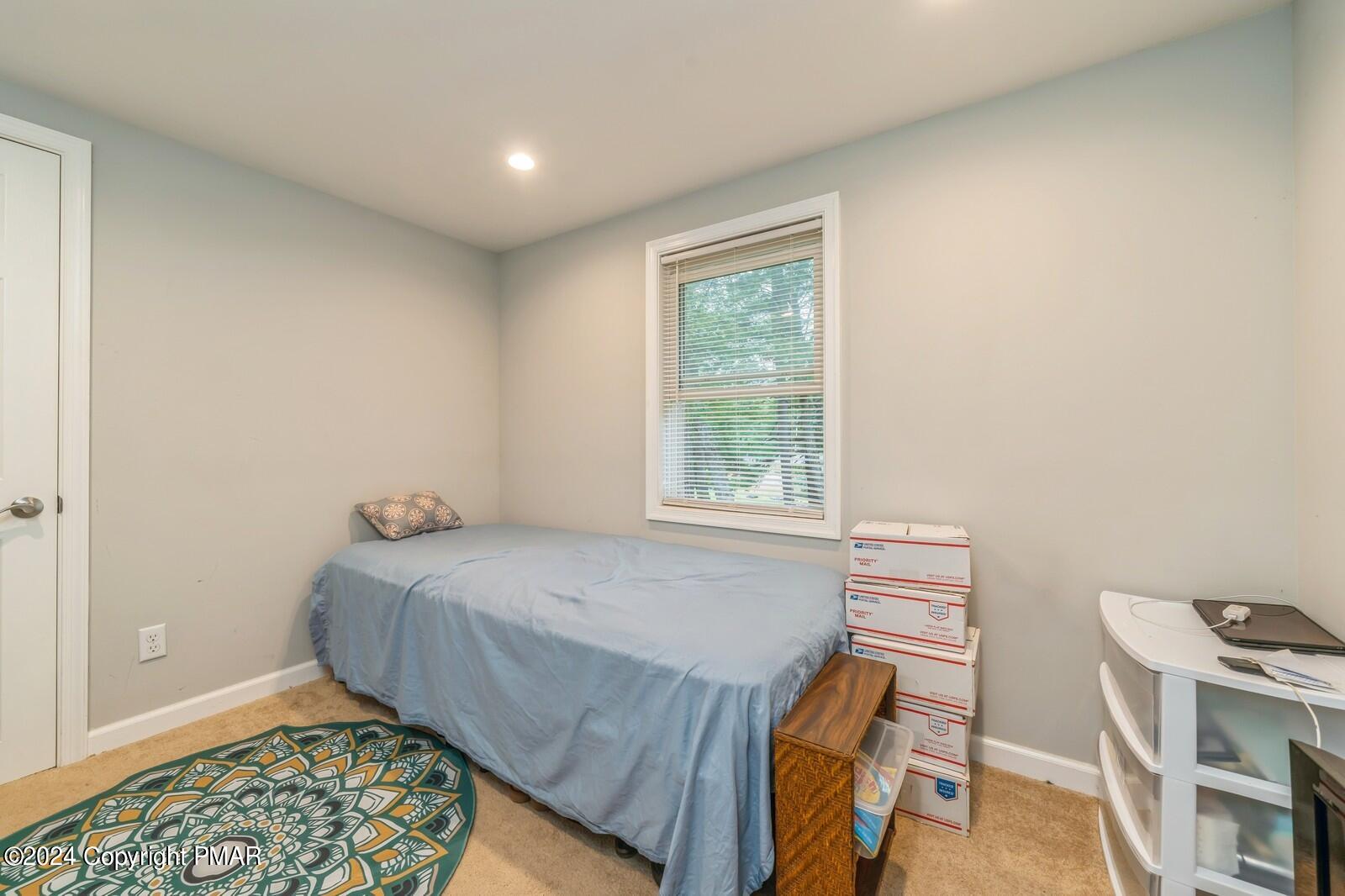 104 Swan Drive Dingmans Ferry, PA 18328 - Photo 21 of 36 a bedroom with a bed and a window