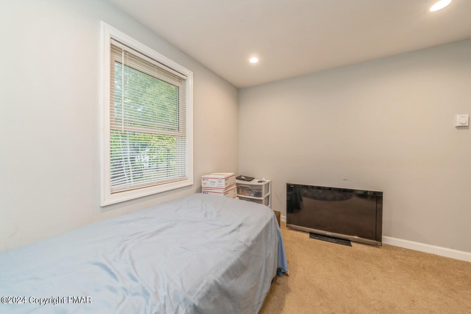 104 Swan Drive Dingmans Ferry, PA 18328 - Photo 22 of 36 a bedroom with a bed and a window