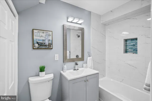 a bathroom with a bathtub sink mirror and toilet