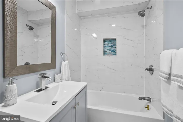 a bathroom with a tub sink and mirror