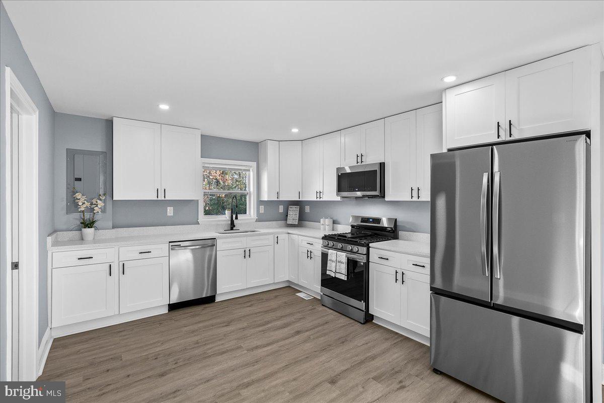 57 Transverse Avenue Middle River, MD 21220 - Photo 20 of 35 a white kitchen with granite countertop stainless steel appliances and wooden cabinets