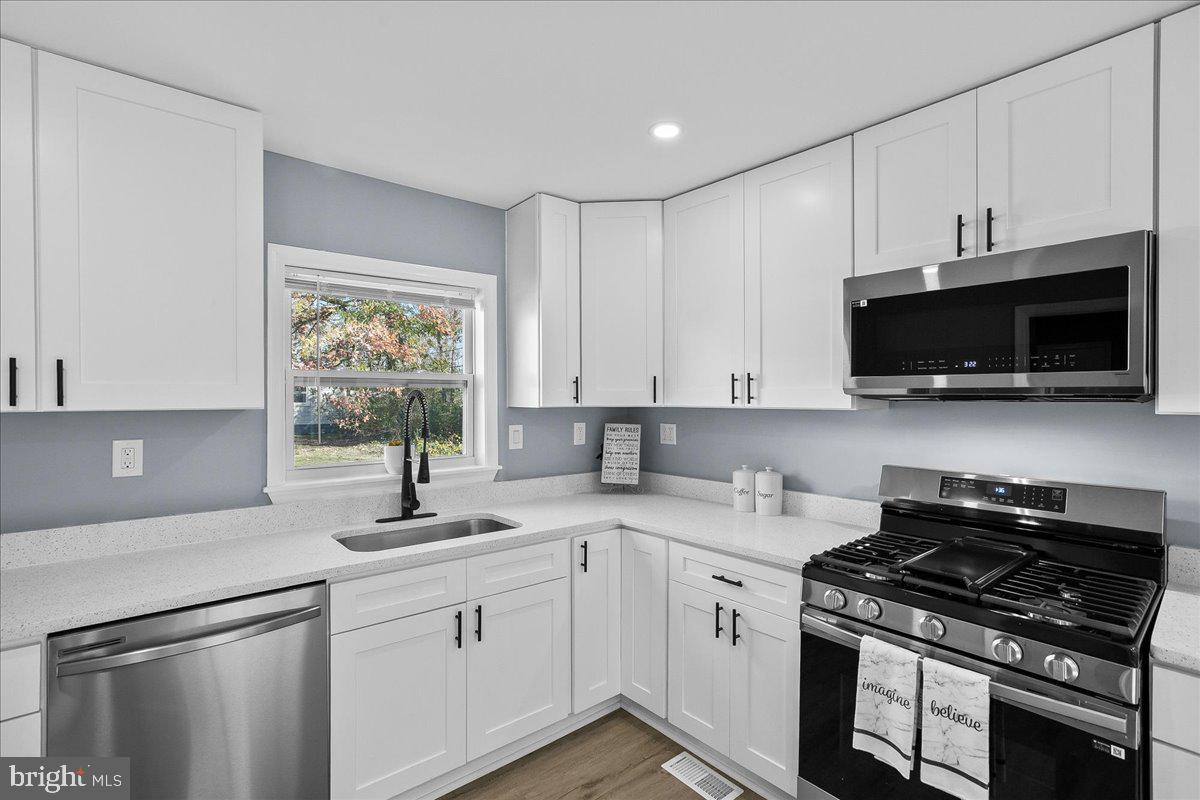 57 Transverse Avenue Middle River, MD 21220 - Photo 21 of 35 a kitchen with stainless steel appliances a sink a stove a microwave and cabinets